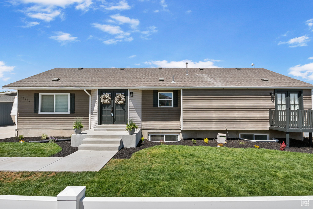 View of front of house with a front lawn and a shingled roof