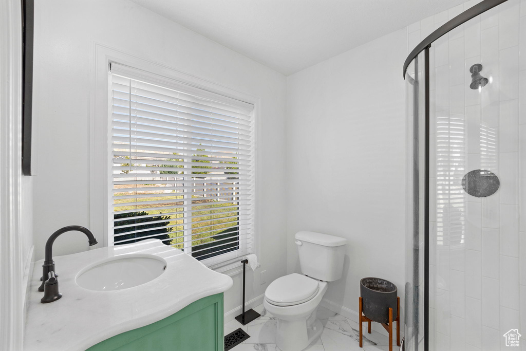 Bathroom with a stall shower, marble finish flooring, toilet, vanity, and baseboards