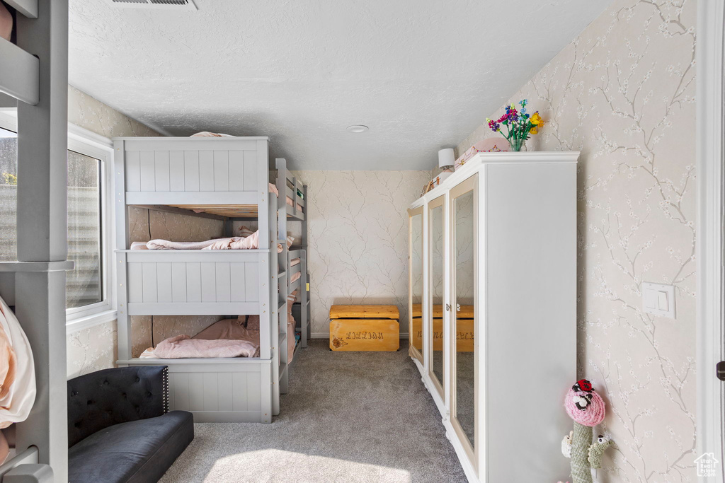 Bedroom featuring carpet flooring and wallpapered walls