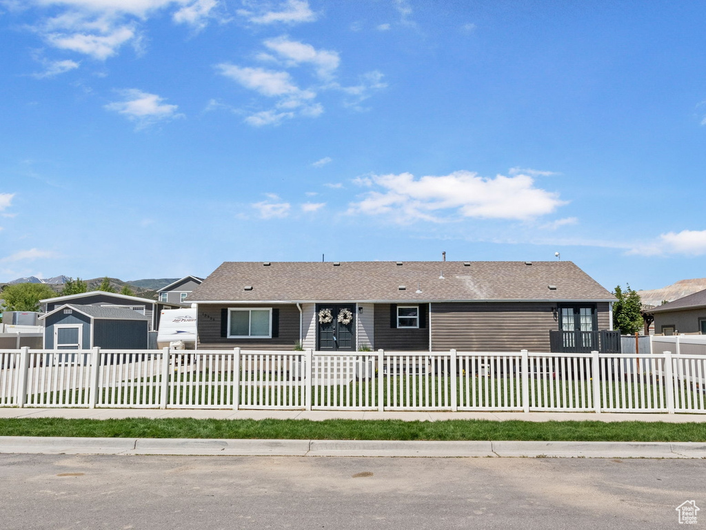 Ranch-style home with a fenced front yard and a residential view