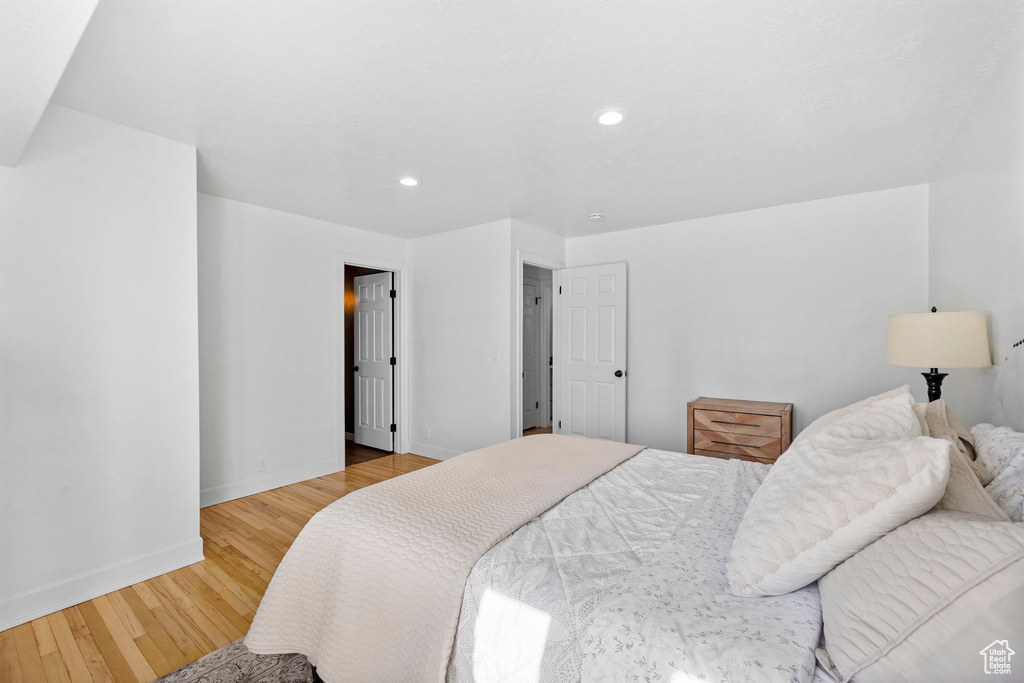Bedroom with light wood finished floors, baseboards, and recessed lighting