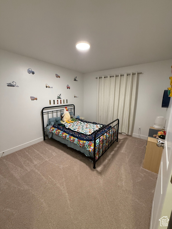 Bedroom with light colored carpet and baseboards