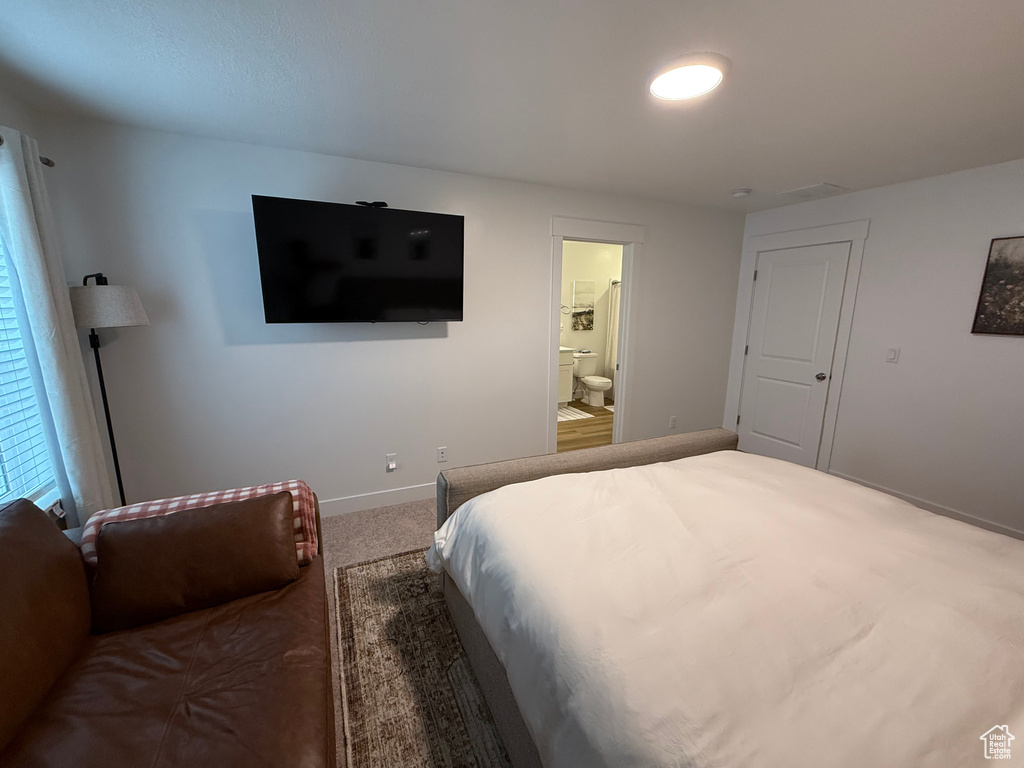 Bedroom featuring baseboards, carpet, and ensuite bathroom