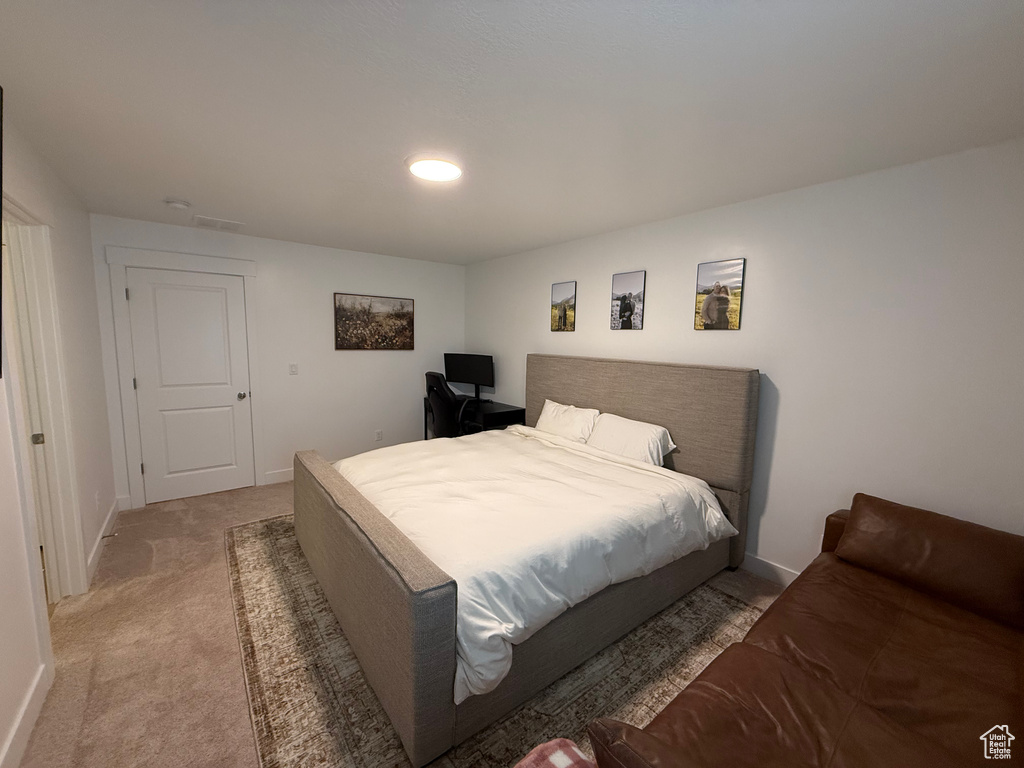 Bedroom featuring light carpet and baseboards