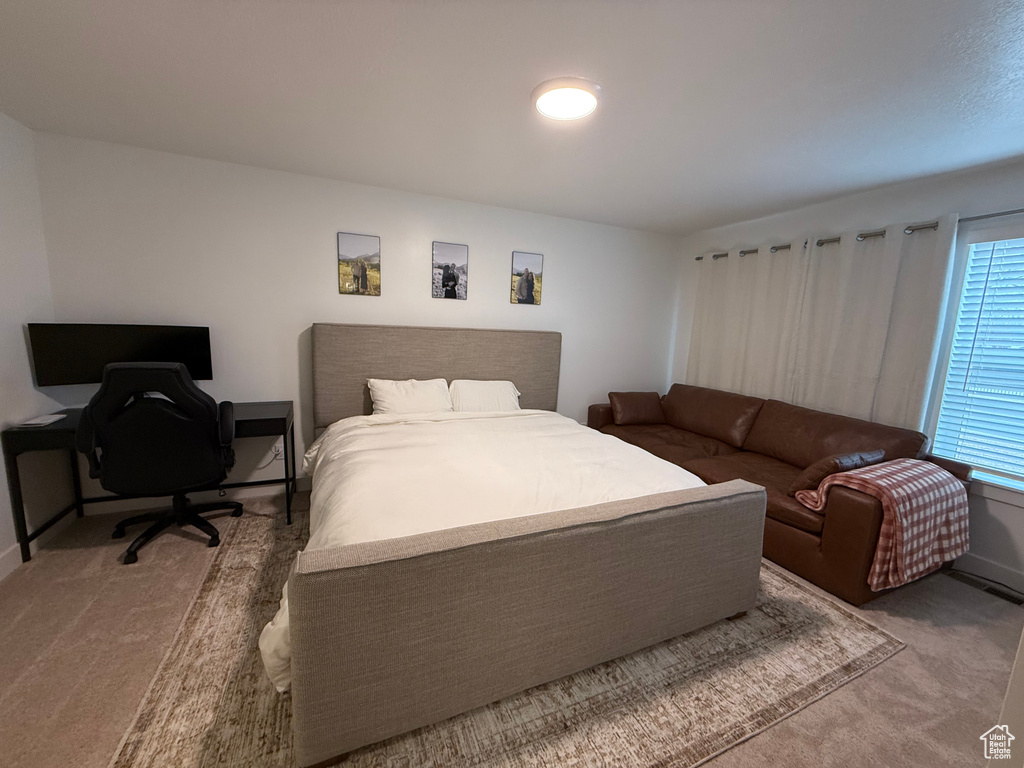 Bedroom featuring carpet and baseboards