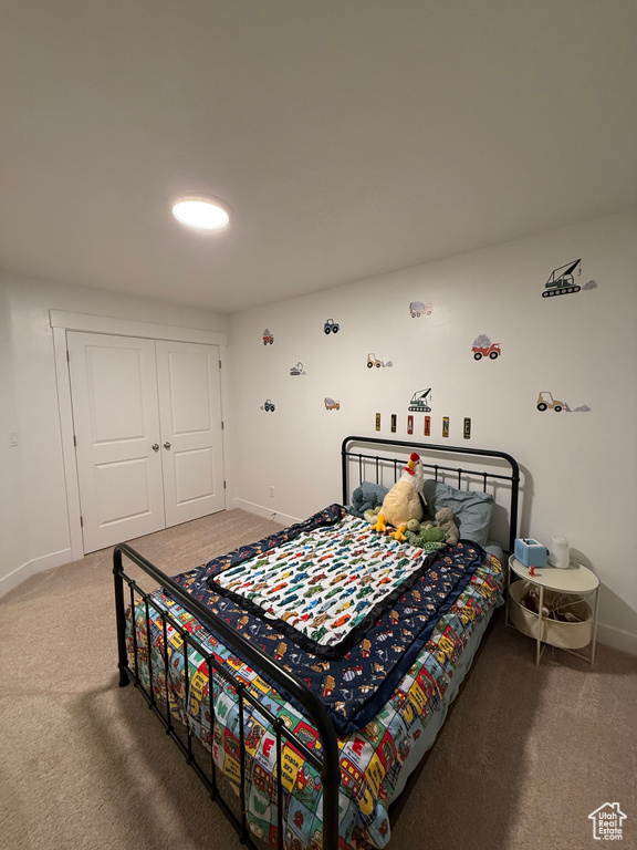 Bedroom featuring carpet flooring, baseboards, and a closet