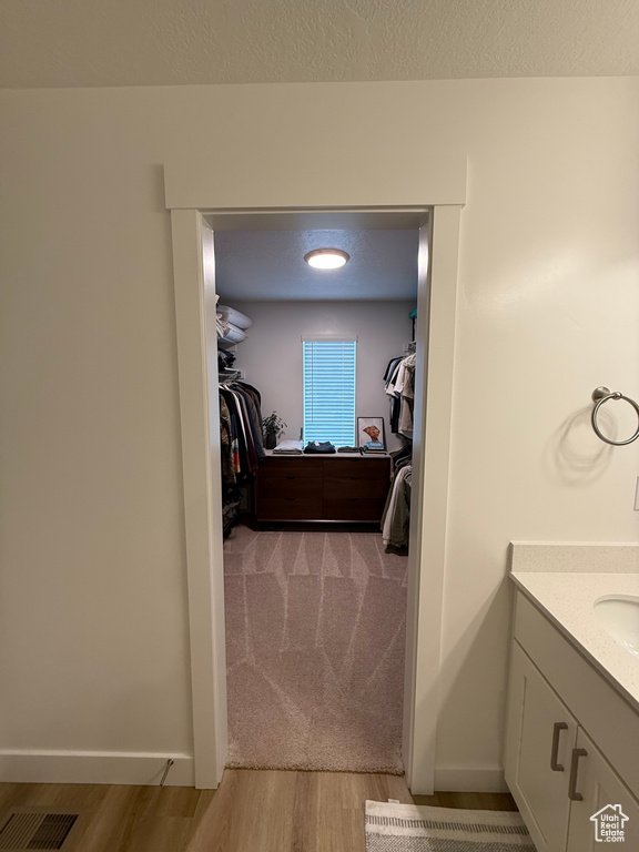 Walk in closet with light wood-style floors
