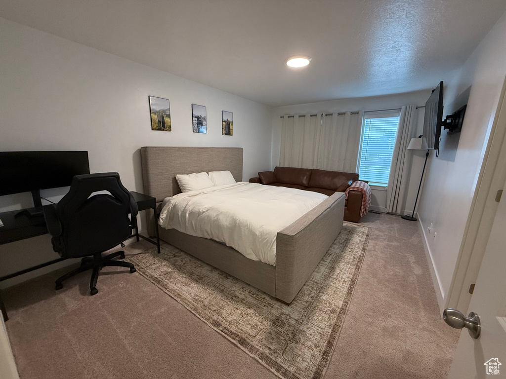 Bedroom featuring carpet flooring, baseboards, and an office area