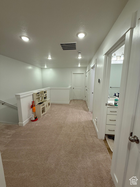 Hall with carpet floors, an upstairs landing, baseboards, recessed lighting, and a textured ceiling