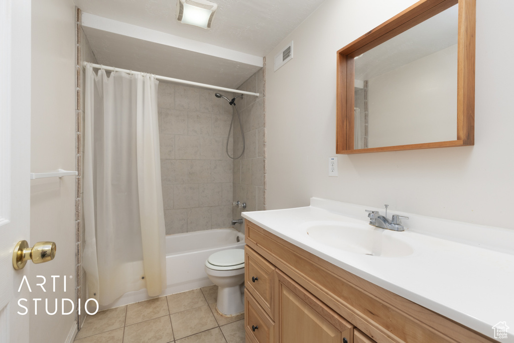 Full bathroom with tile patterned floors, vanity, toilet, and shower / tub combo with curtain