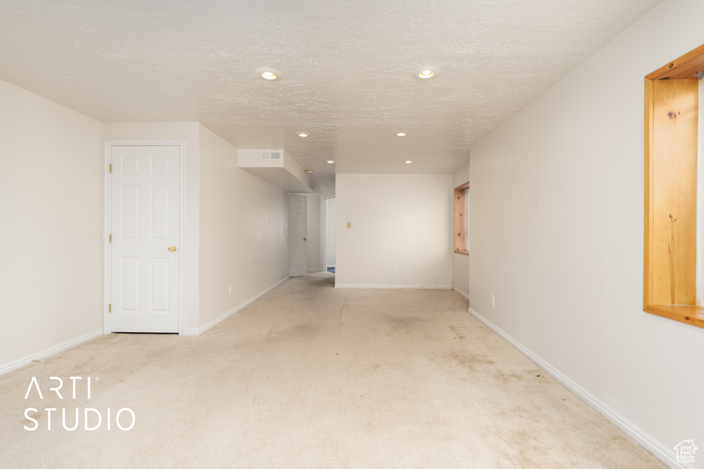 Empty room with light carpet, recessed lighting, and baseboards