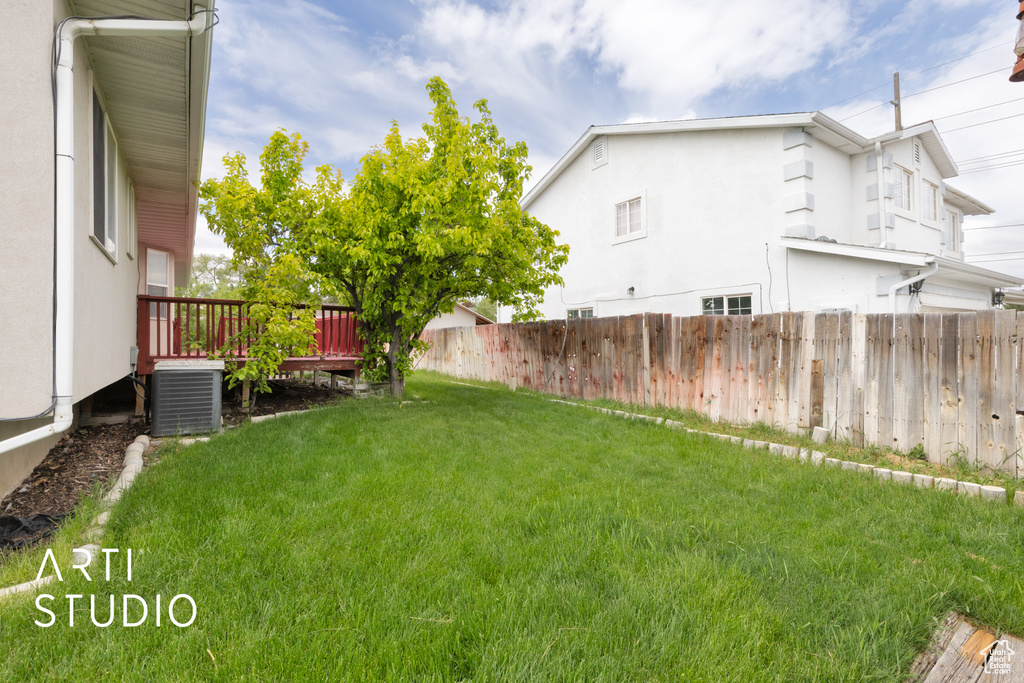 View of yard with cooling unit and a deck