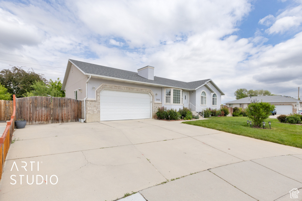 Ranch-style house featuring an attached garage, concrete driveway, stucco siding, and a chimney