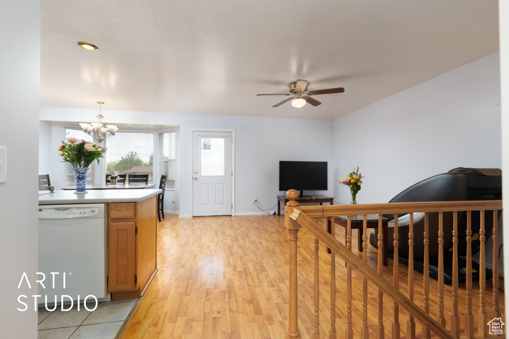 Living room featuring ceiling fan, a chandelier, and light wood finished floors