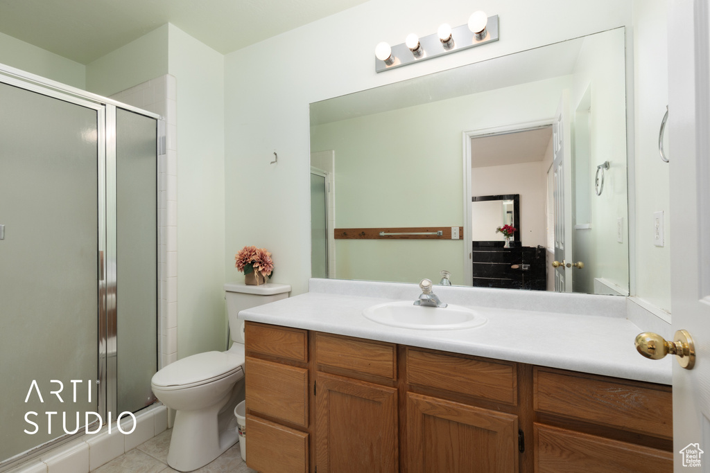 Full bath with a shower stall, tile patterned flooring, toilet, and vanity