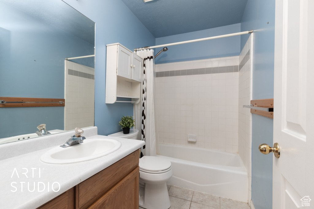 Full bath with tile patterned flooring, toilet, vanity, and shower / bath combo