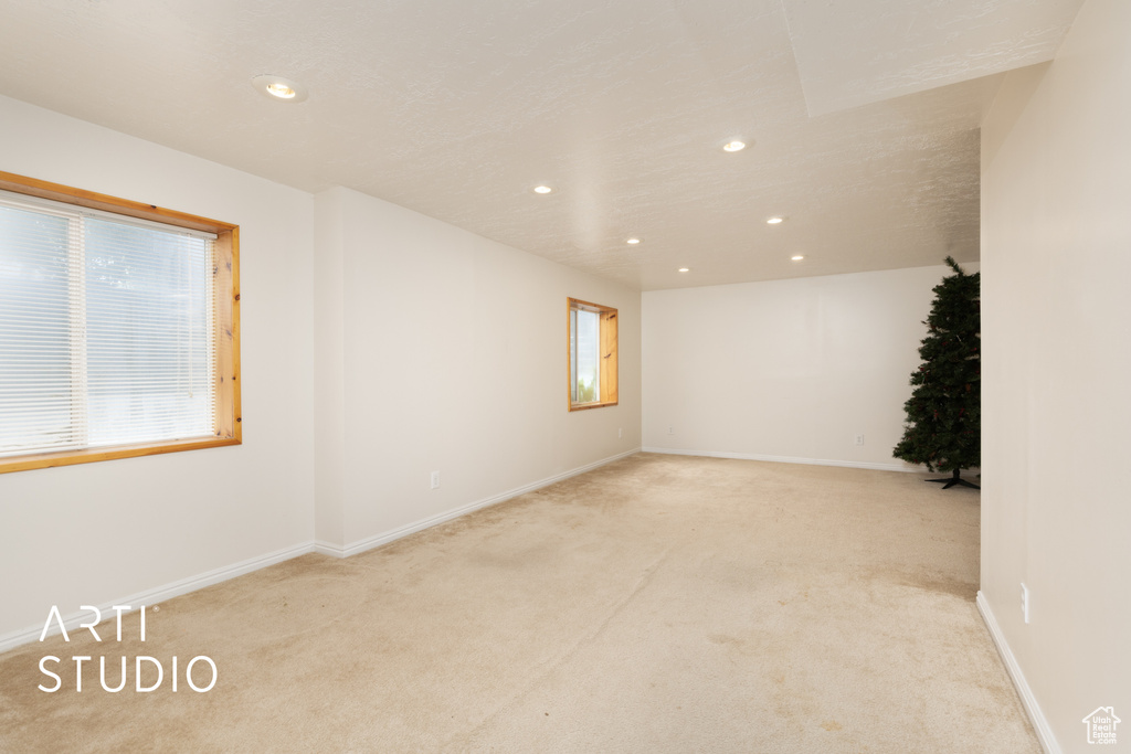 Spare room featuring light carpet, recessed lighting, and baseboards