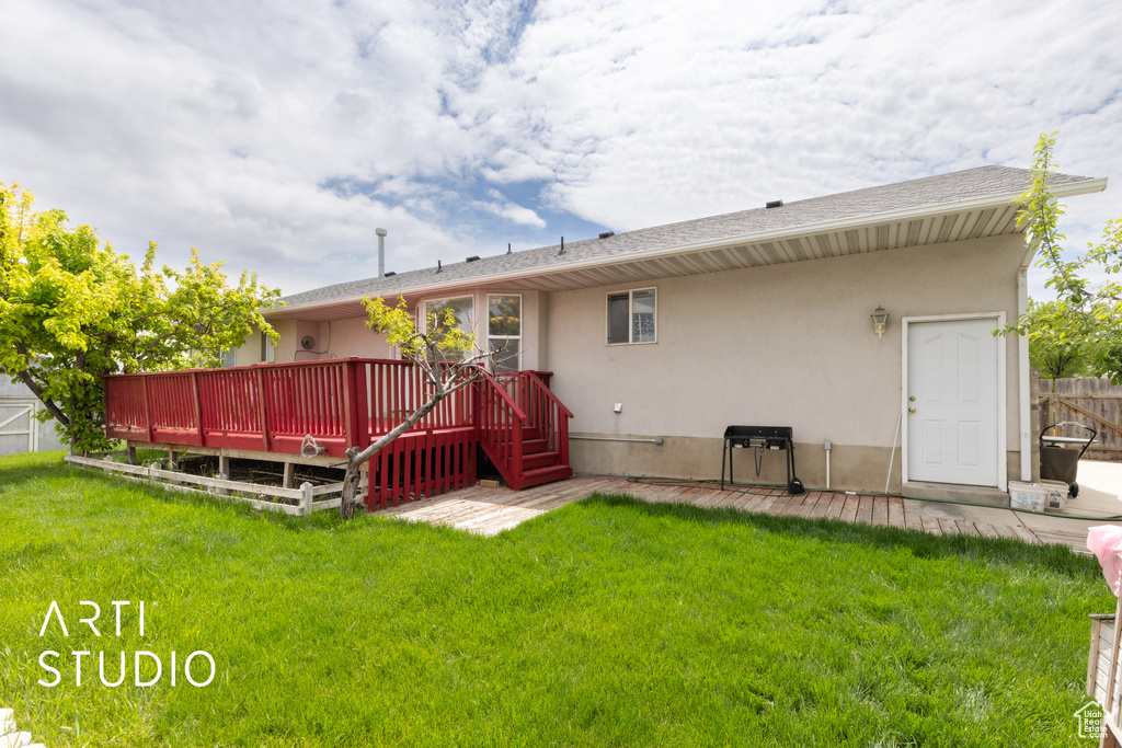 Rear view of house with a wooden deck and stucco siding