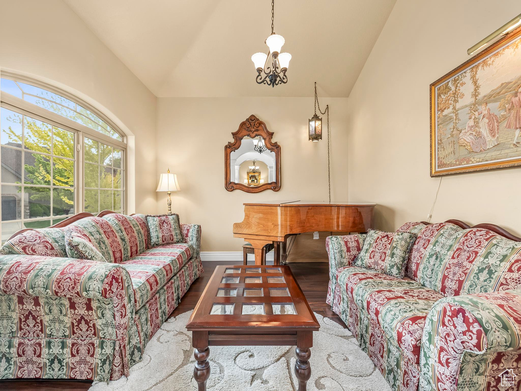 Living area with lofted ceiling, wood finished floors, and baseboards