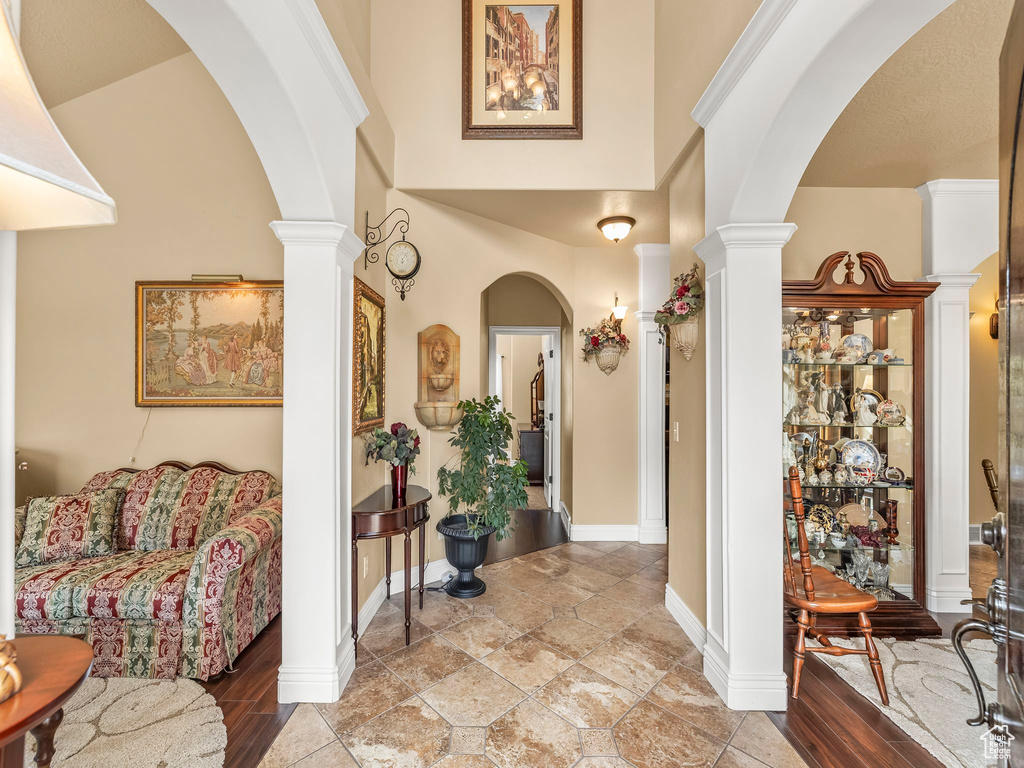 Entryway featuring decorative columns, arched walkways, and baseboards