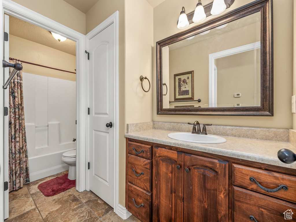 Full bathroom featuring vanity, toilet, and shower / bath combo with shower curtain