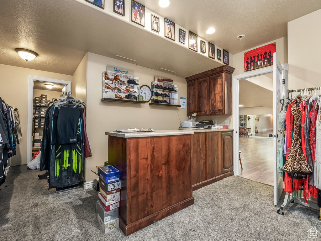 Bar area with carpet flooring and a textured ceiling