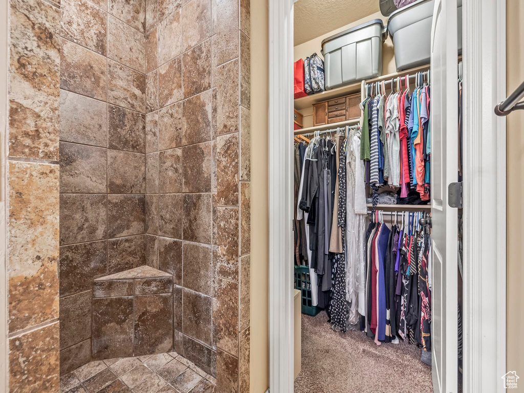 Full bathroom featuring a walk in closet and tiled shower