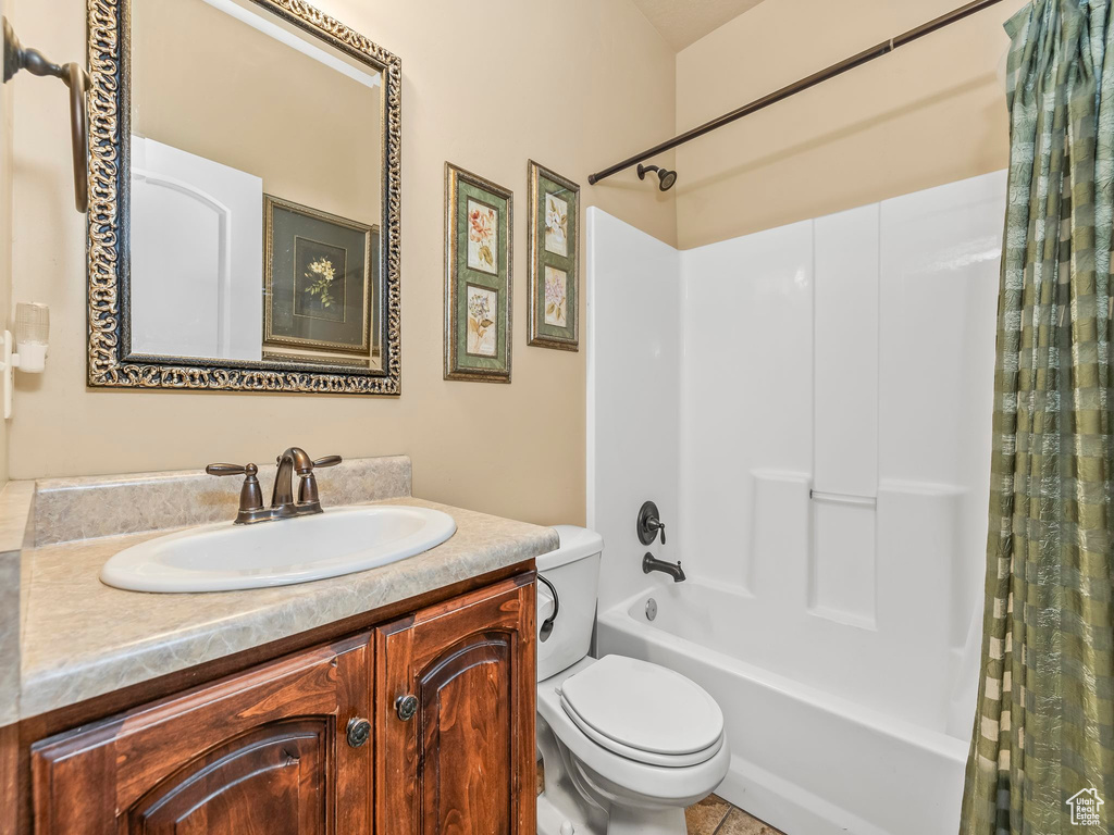 Full bathroom with toilet, shower / tub combo with curtain, and vanity