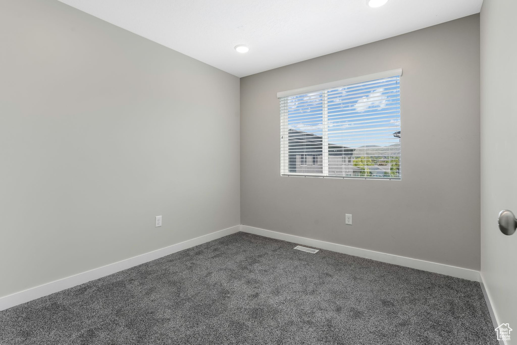 Spare room with dark colored carpet, baseboards, and recessed lighting