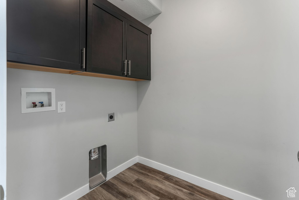 Laundry room with hookup for an electric dryer, cabinet space, washer hookup, baseboards, and dark wood-style floors