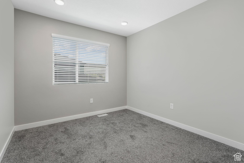 Carpeted empty room featuring baseboards and recessed lighting