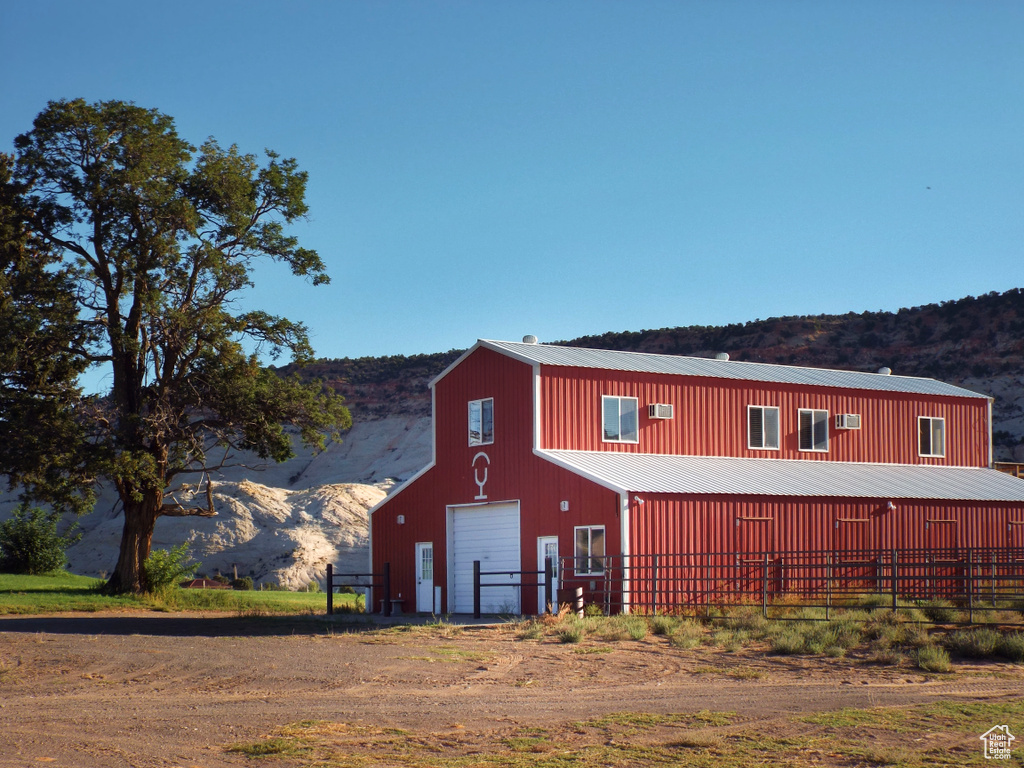 View of pole building with dirt driveway and a mountain view