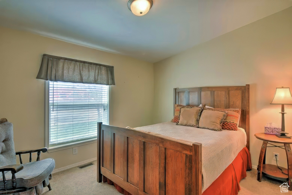 Bedroom featuring baseboards, light carpet, and visible vents