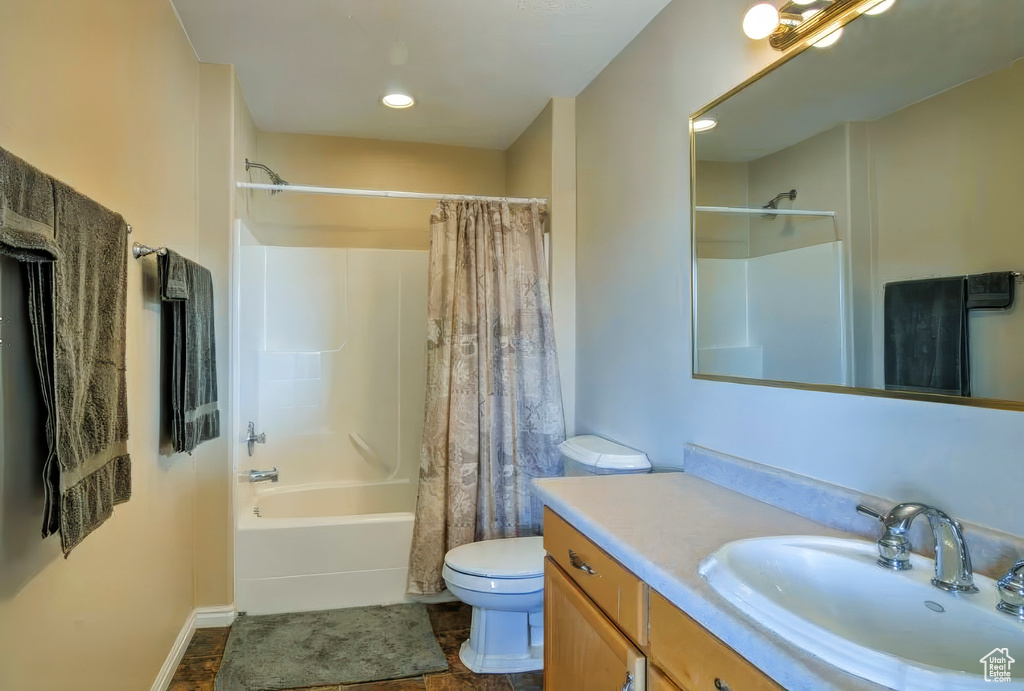 Full bathroom featuring toilet, baseboards, vanity, and shower / bathtub combination with curtain