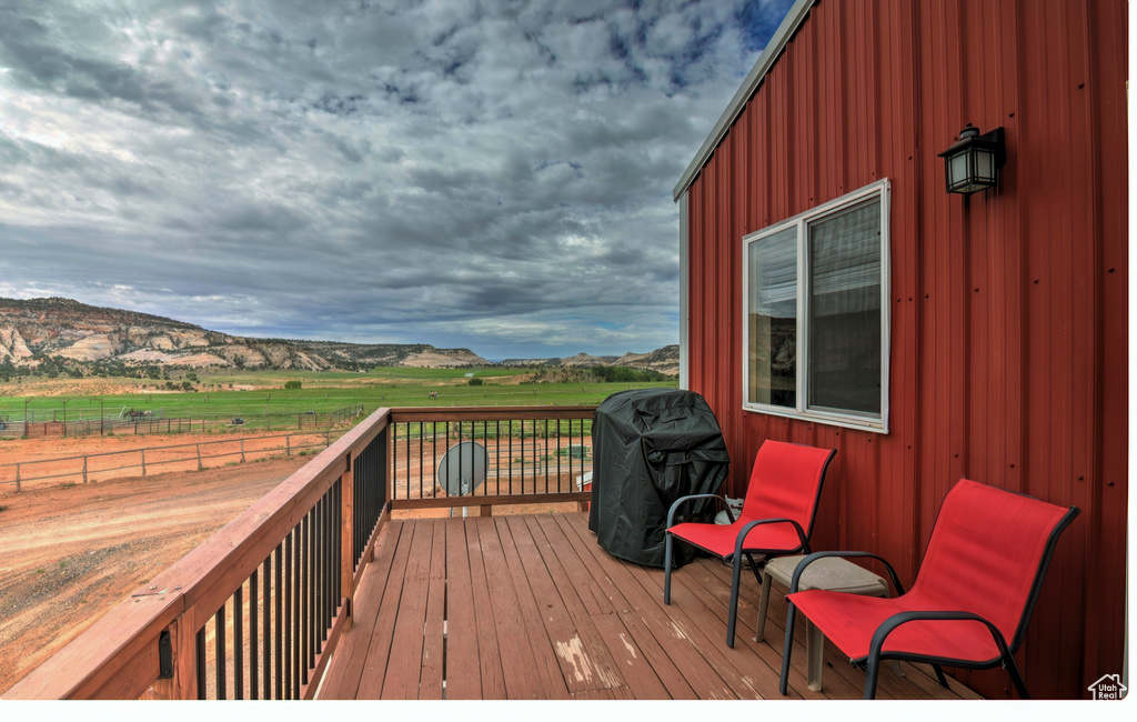 Deck with a rural view, a mountain view, grilling area, and fence