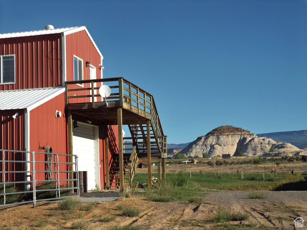 Exterior space with stairs, a deck with mountain view, and a garage