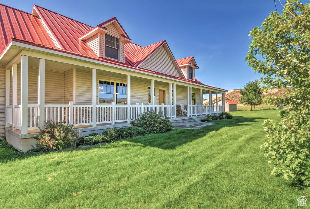 Exterior space featuring metal roof, a porch, and a front lawn
