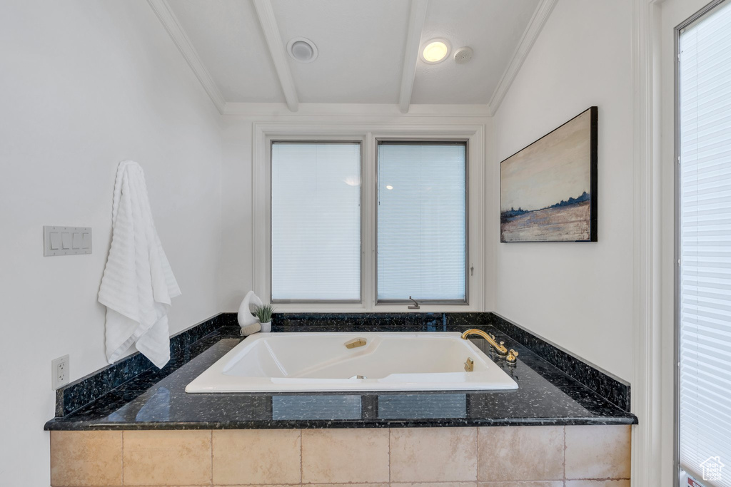 Full bathroom featuring a bath and crown molding