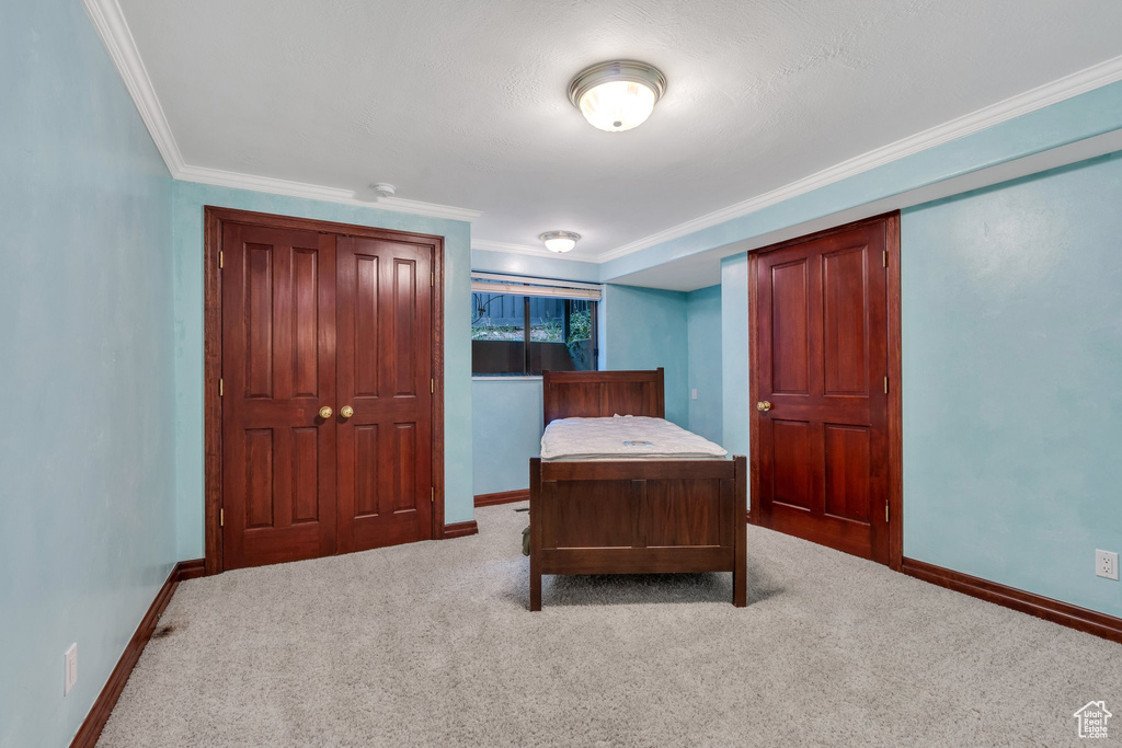 Bedroom featuring baseboards, ornamental molding, and carpet floors