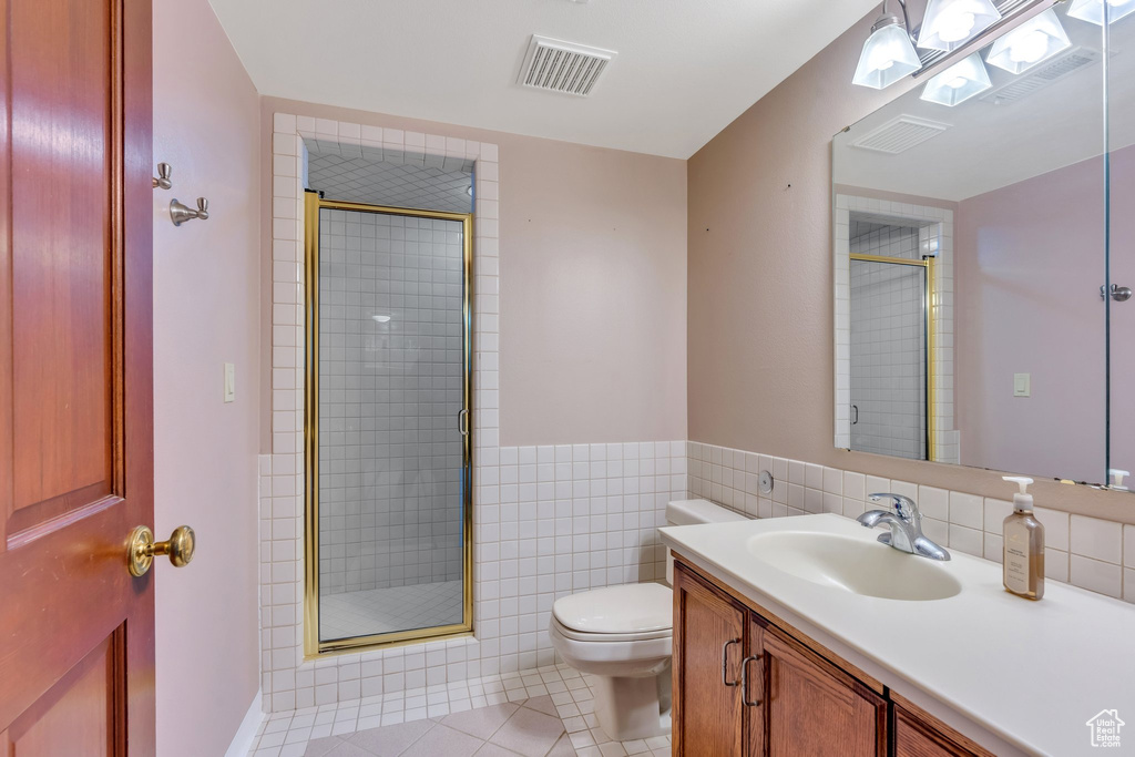 Full bathroom with a stall shower, toilet, tile patterned flooring, and vanity