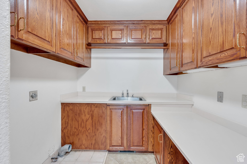 Laundry room featuring electric dryer hookup, cabinet space, and bar with sink