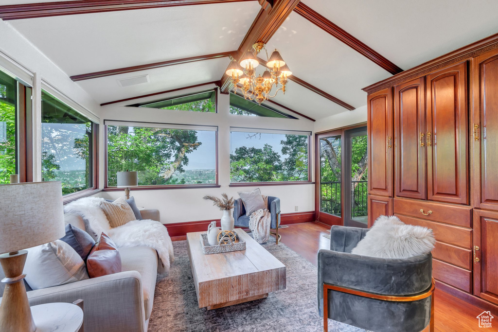 Living room with light wood-type flooring, a chandelier, and baseboards
