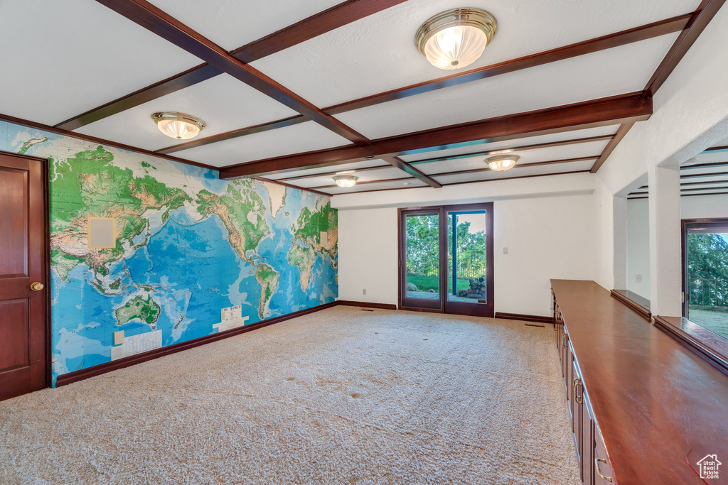 Carpeted empty room with baseboards, beamed ceiling, and wallpapered walls