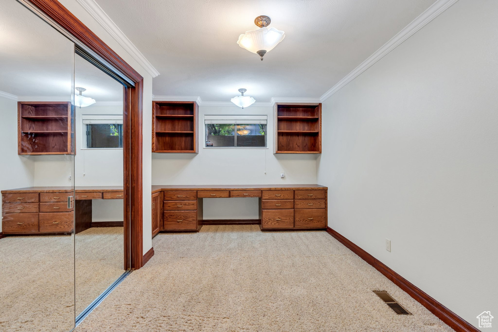 Unfurnished bedroom featuring crown molding, baseboards, and light carpet
