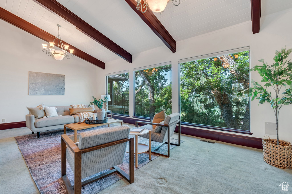 Living room featuring a chandelier, carpet floors, and baseboards
