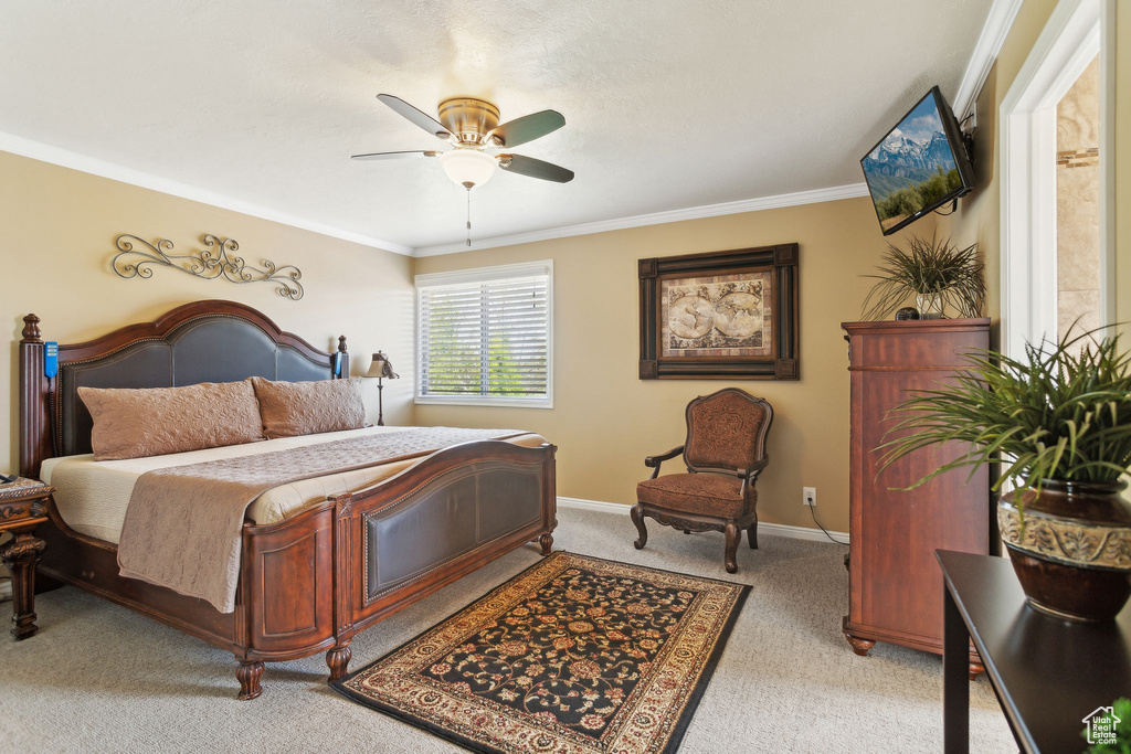 Bedroom with light colored carpet, crown molding, a ceiling fan, and baseboards
