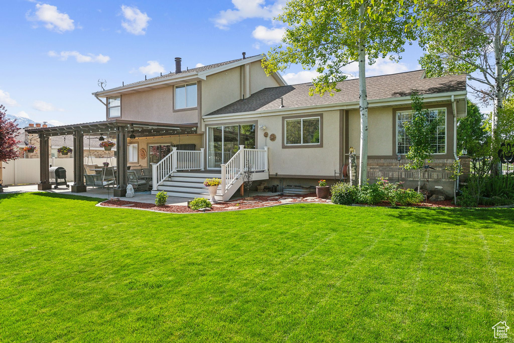 Back of house featuring a patio area, a pergola, roof with shingles, and stucco siding