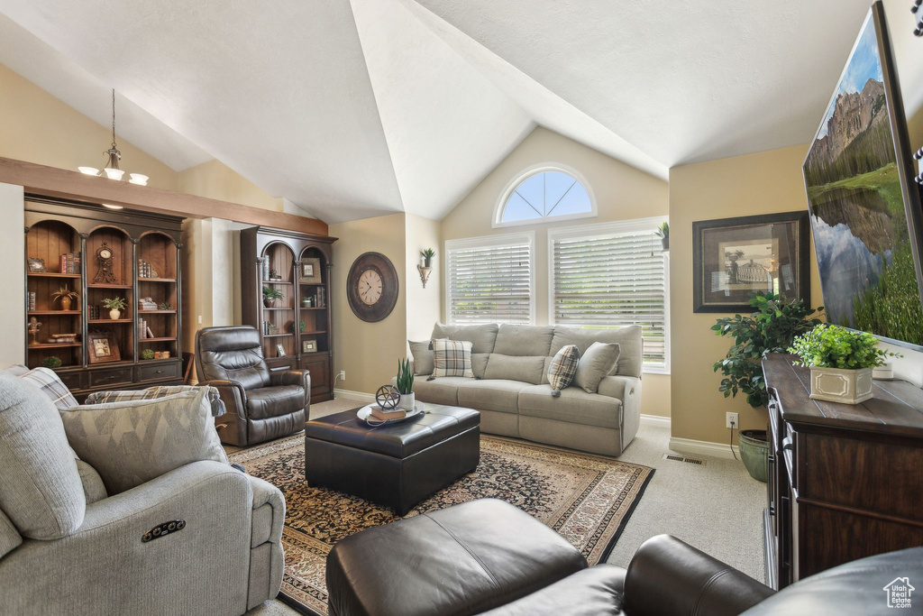 Living area with lofted ceiling, baseboards, and light colored carpet
