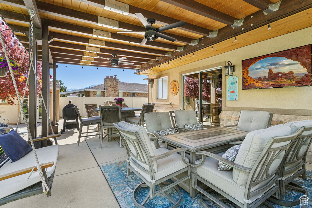 View of patio with outdoor dining area, a ceiling fan, and fence