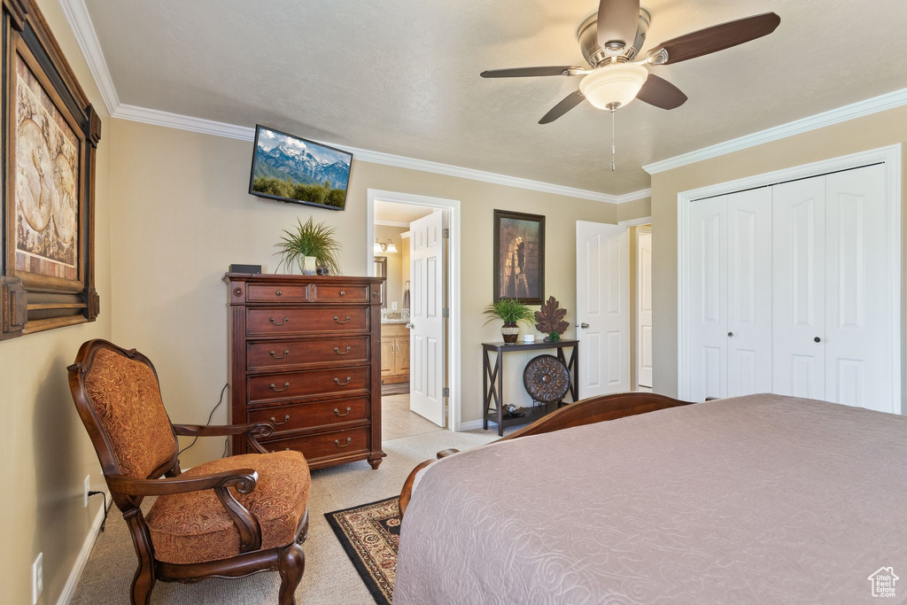 Bedroom with baseboards, light colored carpet, ornamental molding, a closet, and ensuite bathroom